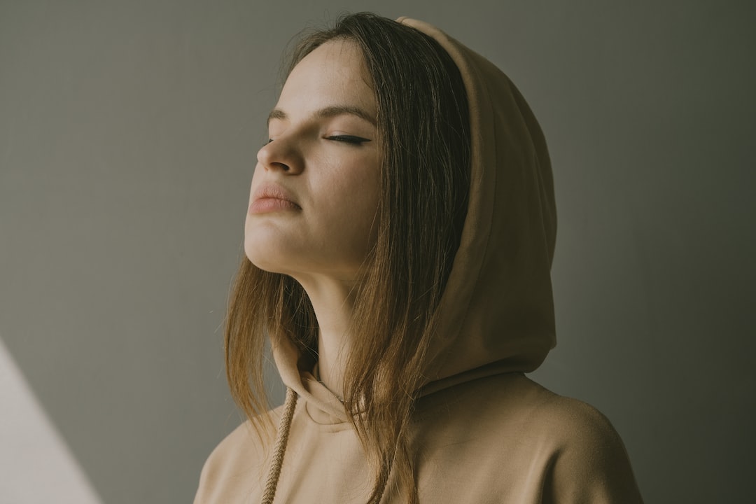 Girl with a brown hood closing her eyes