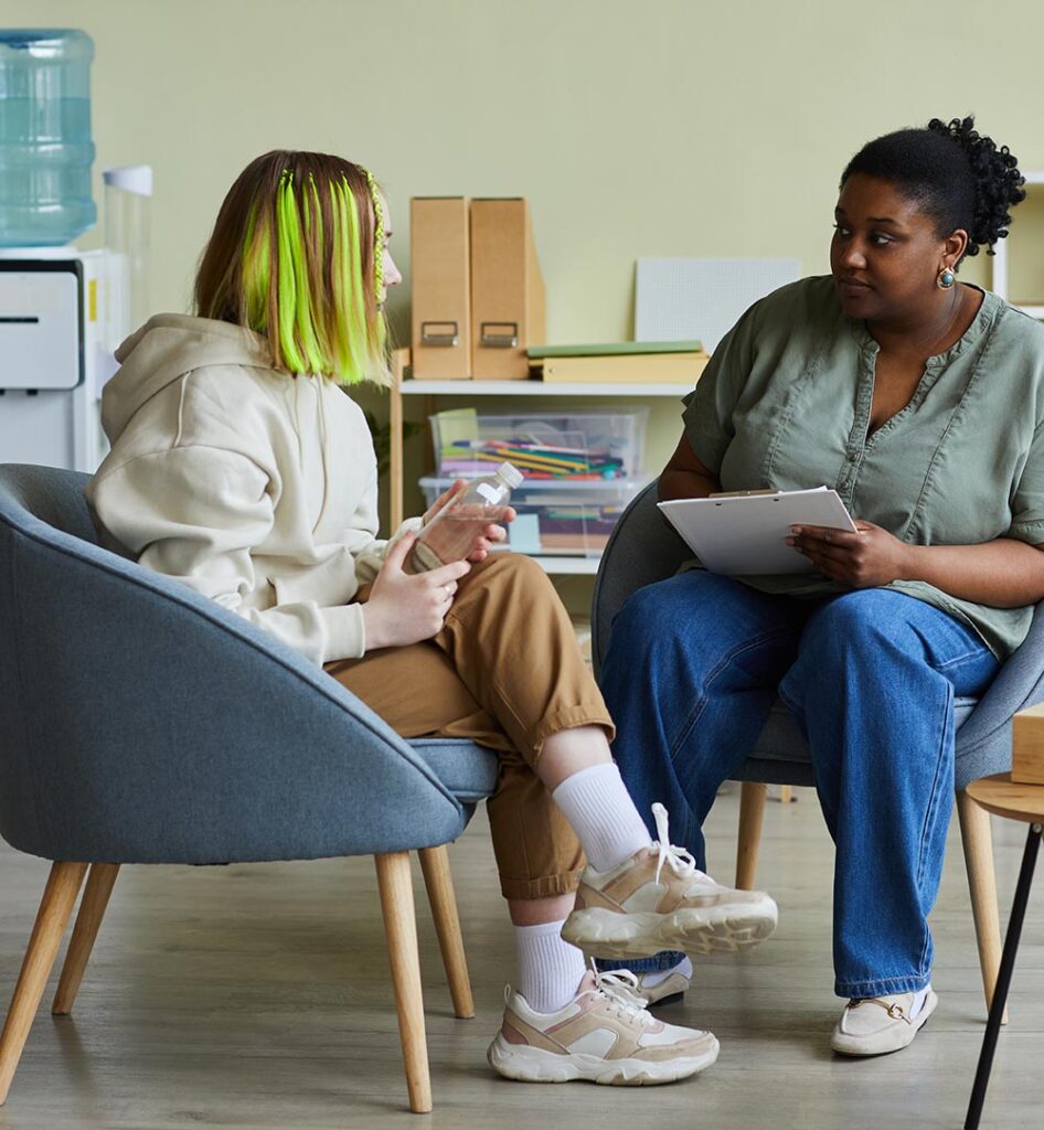 Image of a teen girl speaking to an adult woman. Help your teen cope and manage the pressure that come with being a teen with teen therapy in South Jersey.