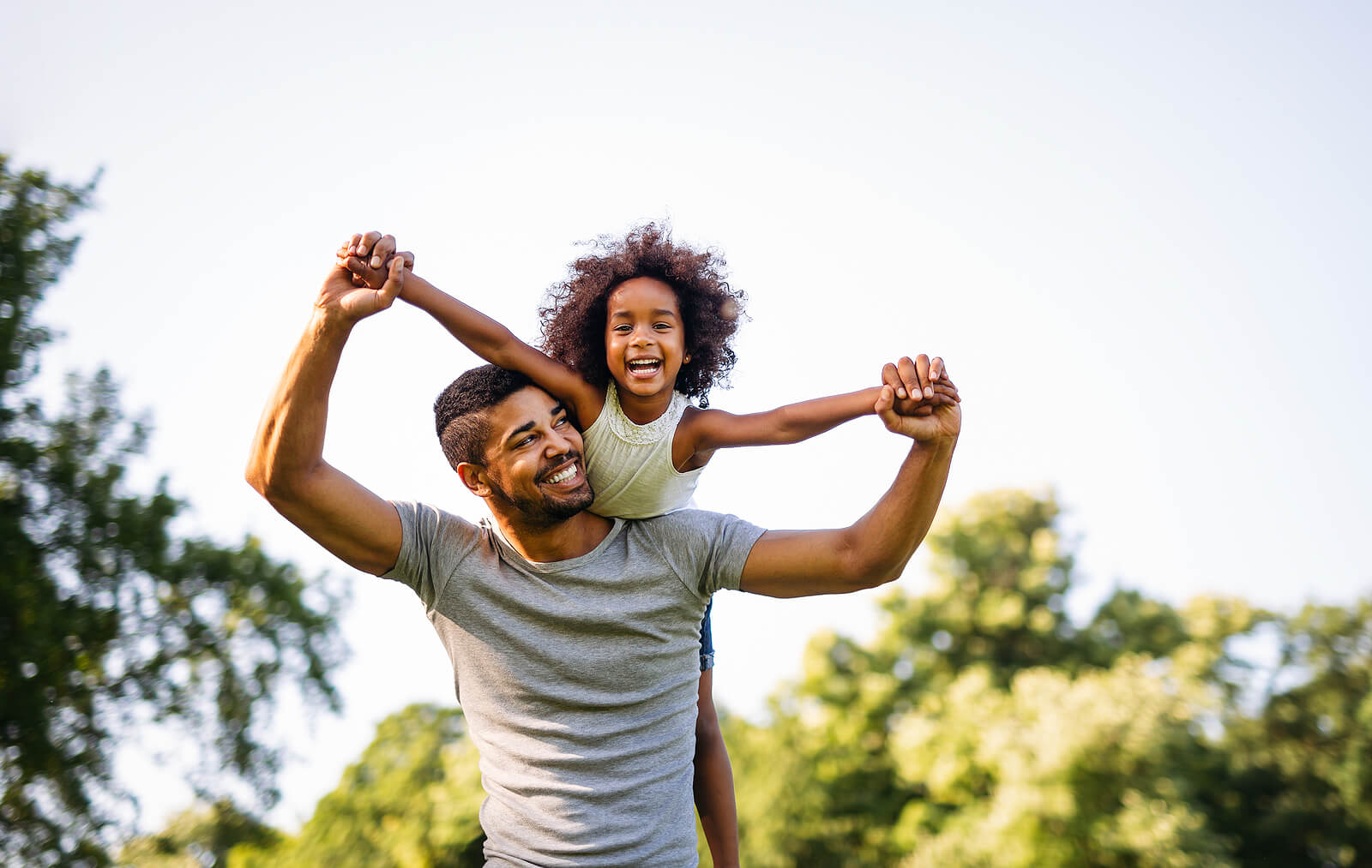 Image of a smiling father carrying his smiling daughter on his back. With therapy for children in South Jersey your child can begin healing and coping with their big emotions in big ways.