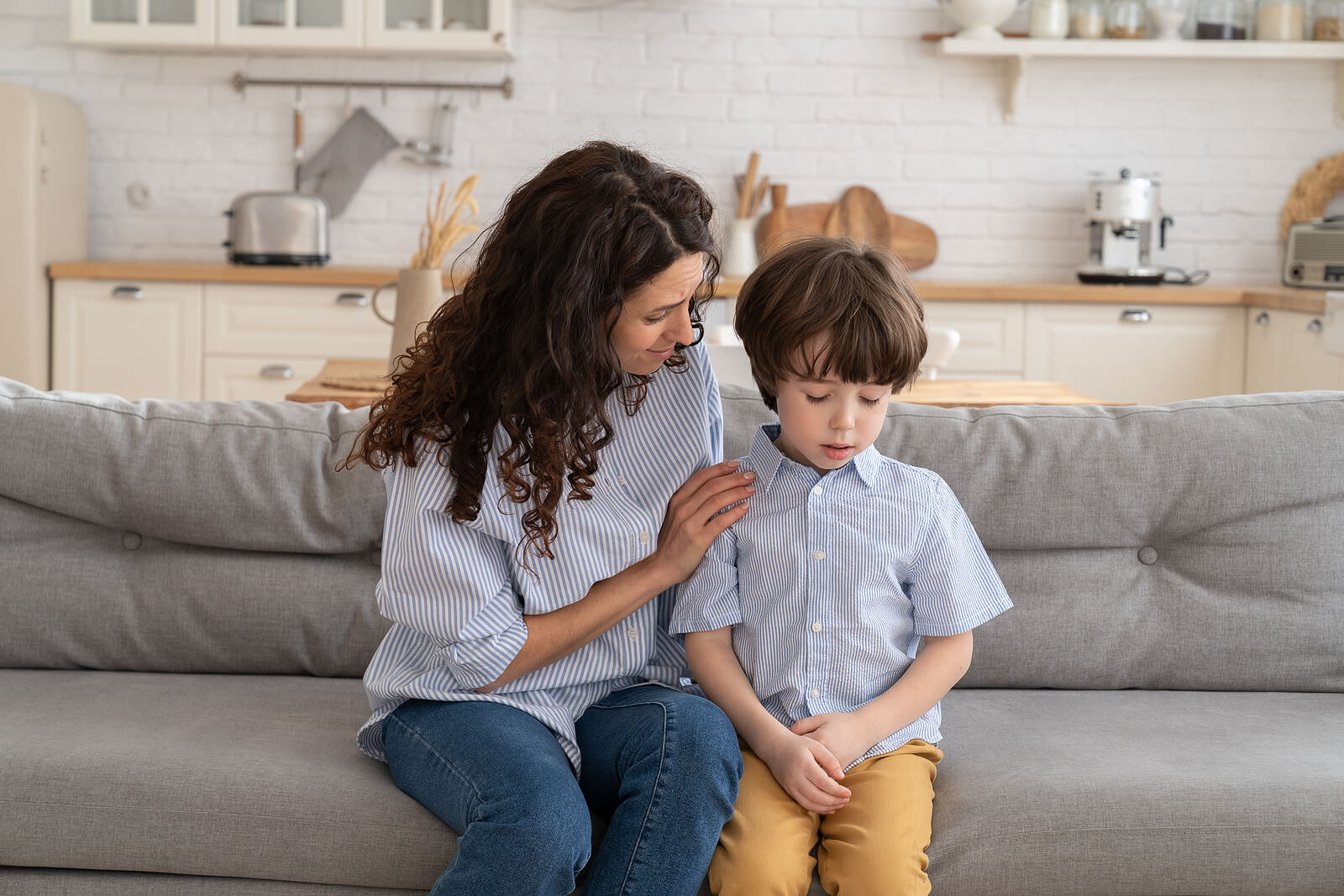 Mother sitting on a couch comforting her young depressed son. Depression in children can often be overlooked. With the support of a child therapist in South Jersey, your child can begin to cope with their emotions in healthy ways.