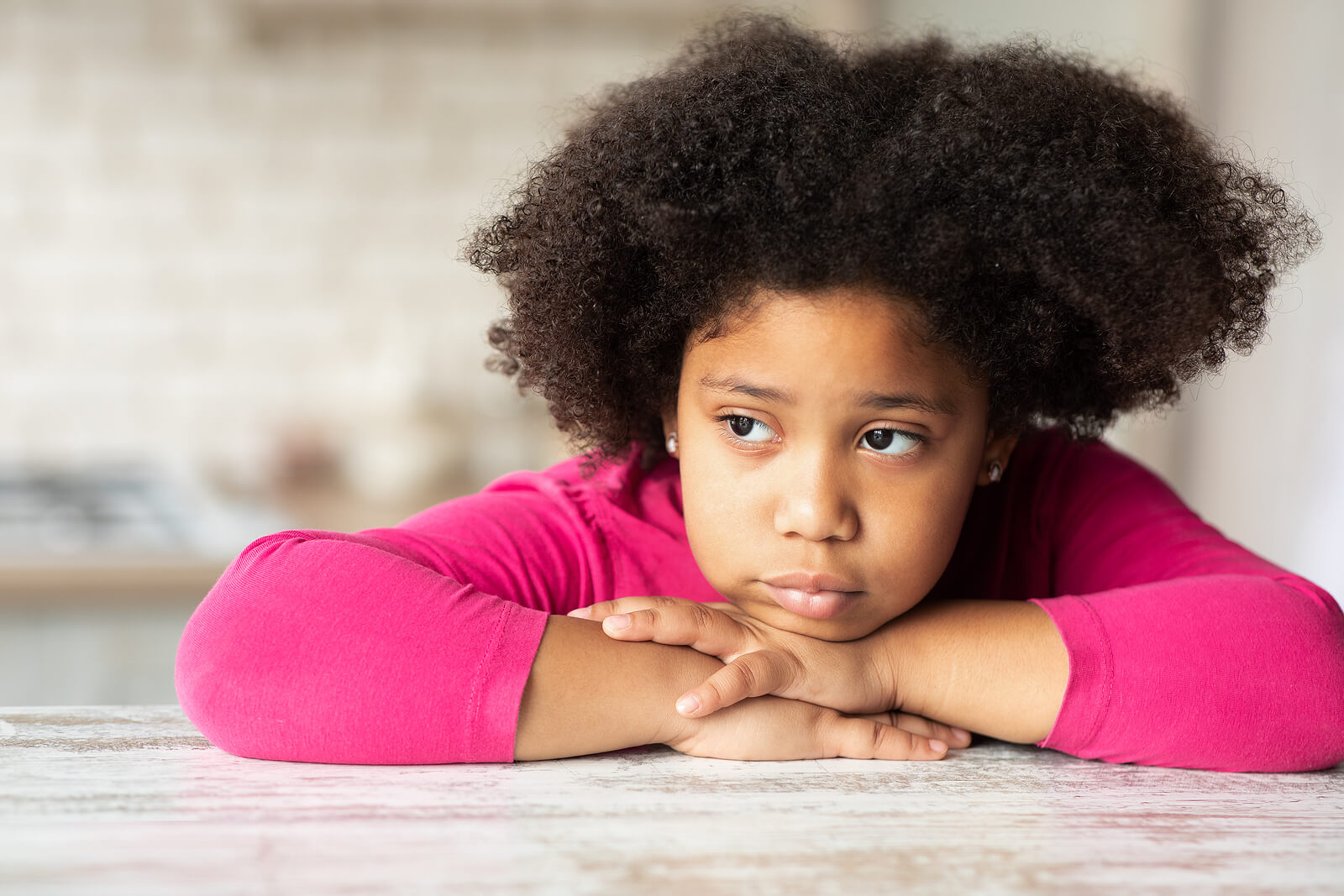 Image of a sad little girl resting her chin on her hands. Is your child struggling to cope with their anxiety? With the help of therapy for children in South Jersey, your child can learn to cope with their symptoms. 