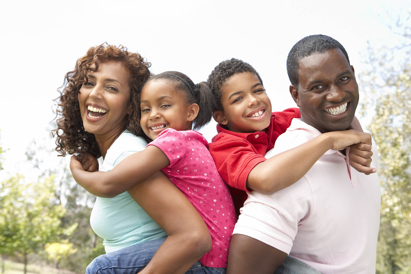 Happy parents carrying their children on their backs. With therapy for children in South Jersey, your child can begin to cope and start healing from the depression symptoms disrupting their lives.