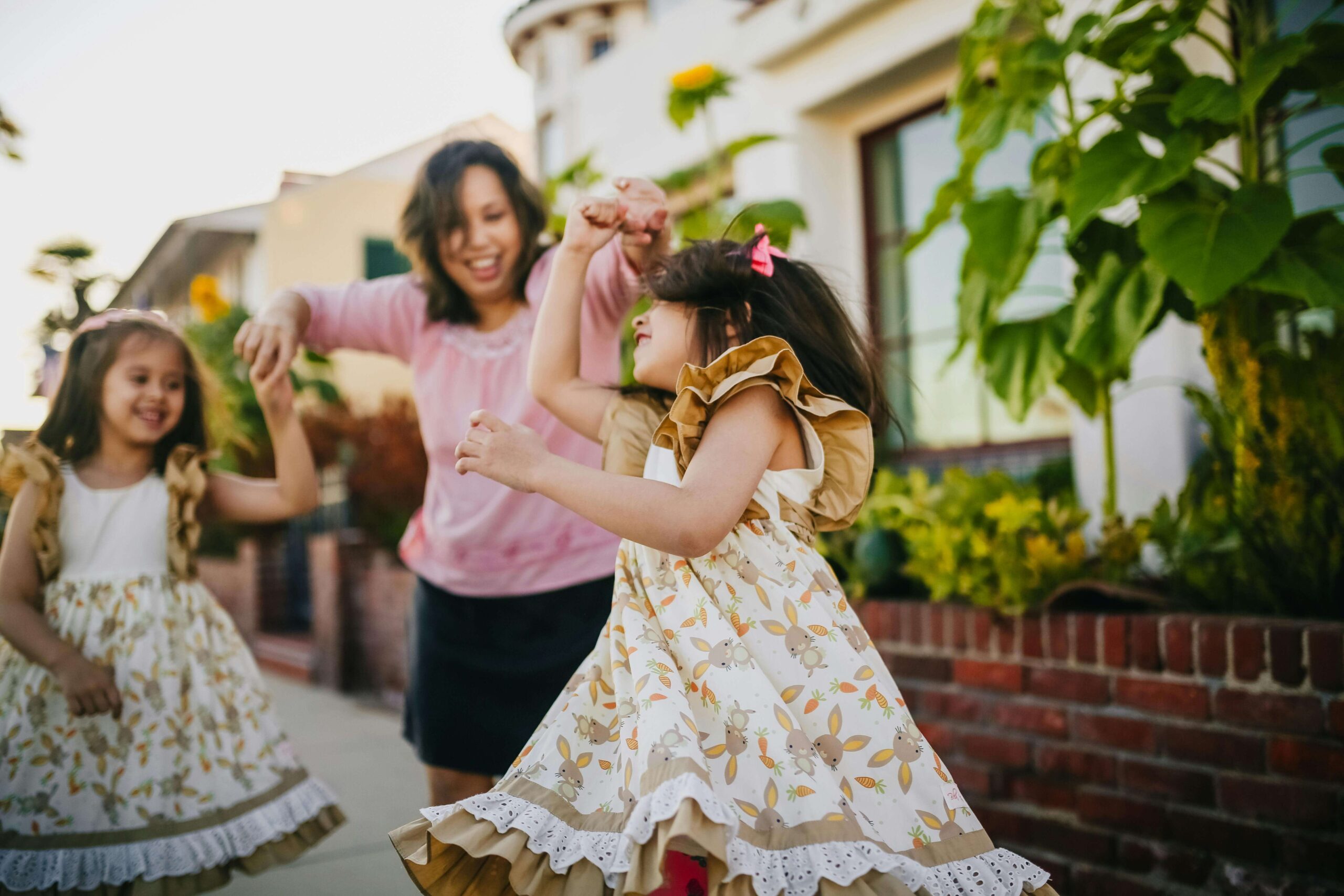 Happy mother dancing outside with her two younger daughters. Help your child learn to build their emotional strength and build healthier relationships with the help of therapy for children in South Jersey.