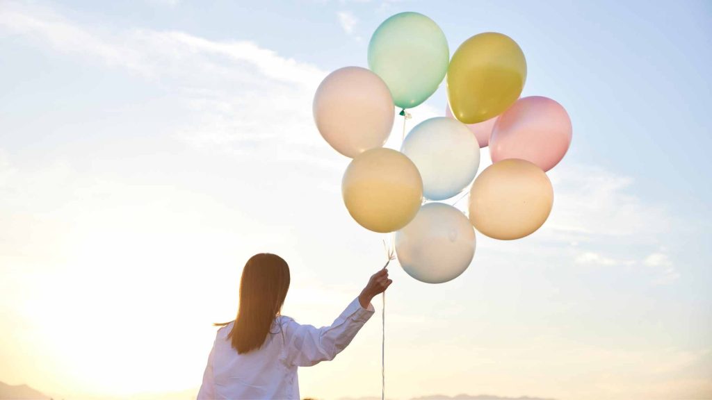 Woman with a bunch of balloons in the sunset. Consider DBT with expert therapists in South Jersey today. Visit our Voorhees and Moorestown therapist offices for the best therapy in New Jersey!