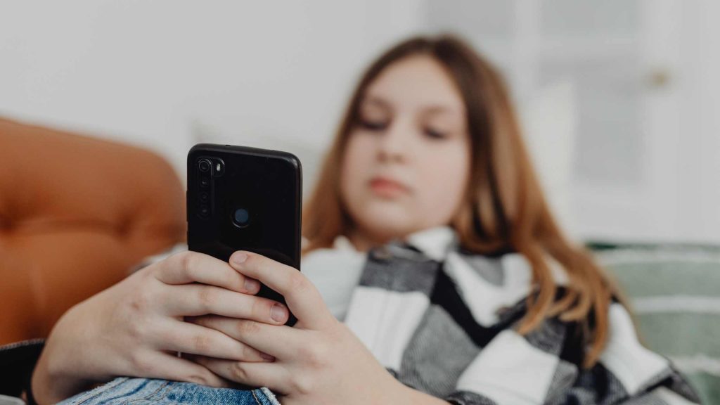 Woman on her phone multitasking. Get extra help during the busy time of the stressful year from the best therapists in New Jersey here.