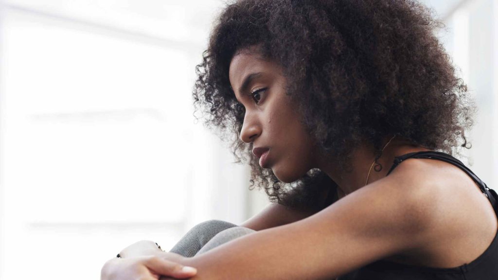 Woman sitting looking upset. Read the full trauma & PTSD therapist blog post about How the body stores trauma DBT of South Jersey ART for Fast Trauma Healing