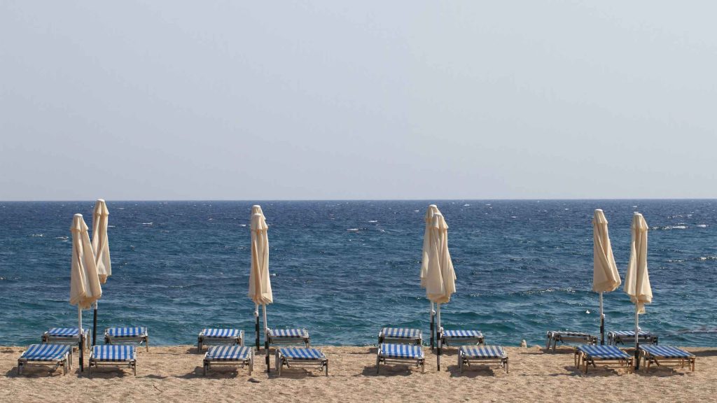 Empty beach lounge chairs and folded umbrellas line the shoreline as summer winds down, marking the seasonal shift into fall school routines that DBT of South Jersey helps families navigate.